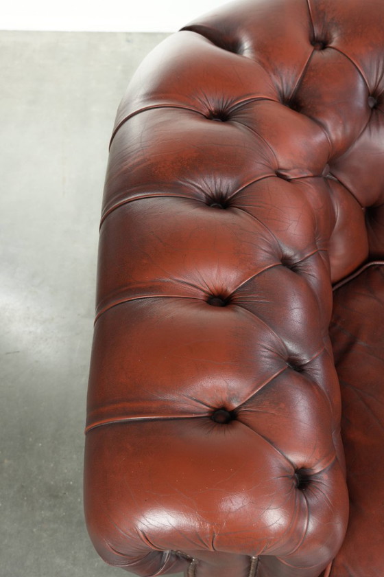 Image 1 of Beautiful red/brown cowhide Chesterfield armchair in a classic English style