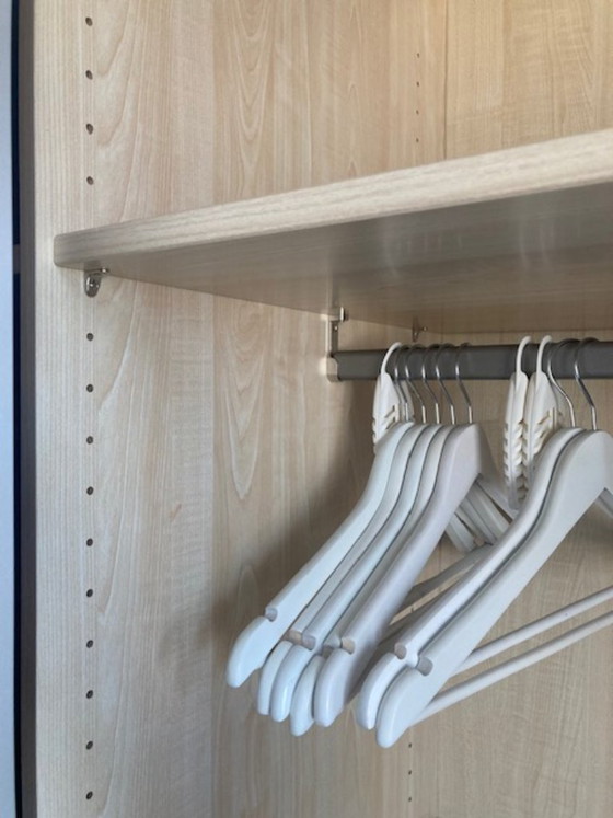 Image 1 of Armario moderno IKEA PAX que va desde el suelo hasta el techo, con puertas correderas de cierre suave.
