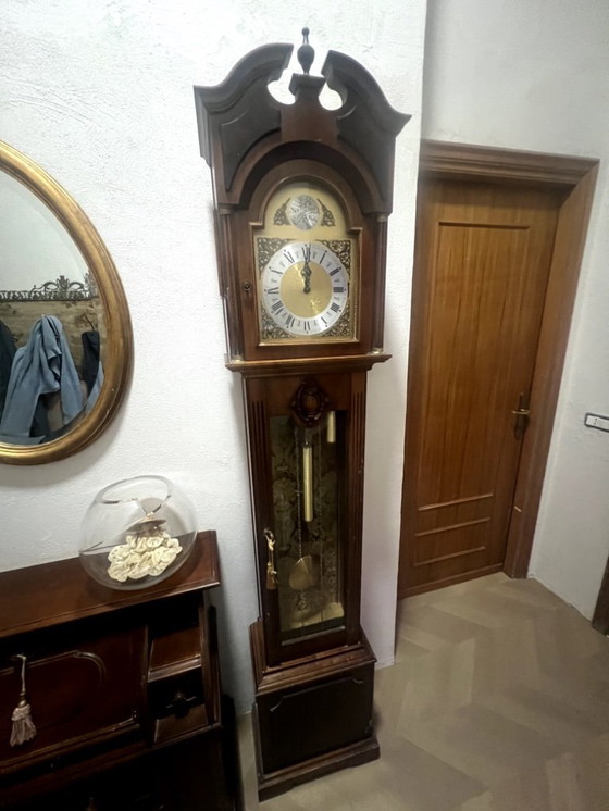 Image 1 of Eine hölzerne Pendeluhr mit einem Schweizer mechanischen Uhrwerk