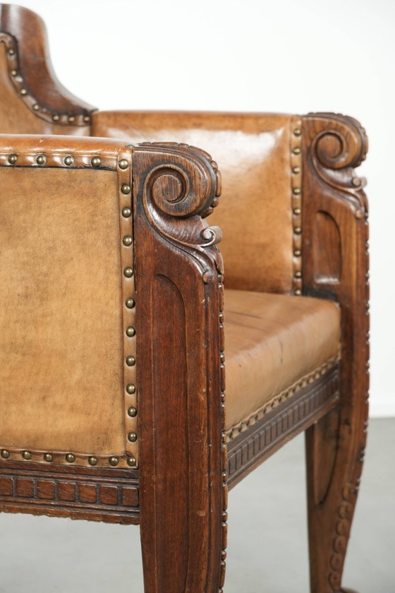 Image 1 of Antique armchair of sheepskin and wood with decorative nails and beautiful woodwork
