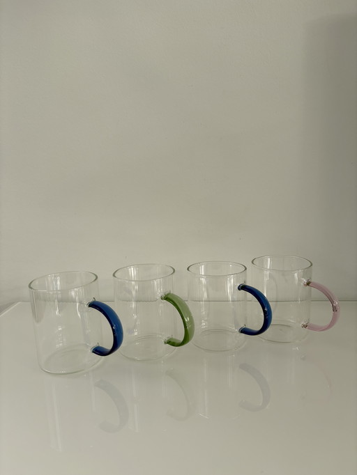 Set of four modern design mugs with colored handles