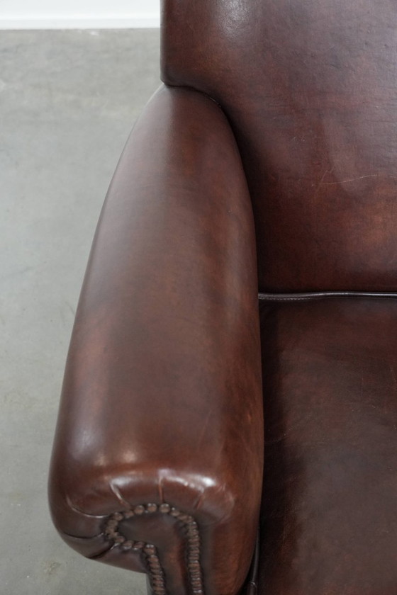 Image 1 of Fauteuil en peau de mouton aux couleurs chaudes et à la finition classique orné de clous décoratifs