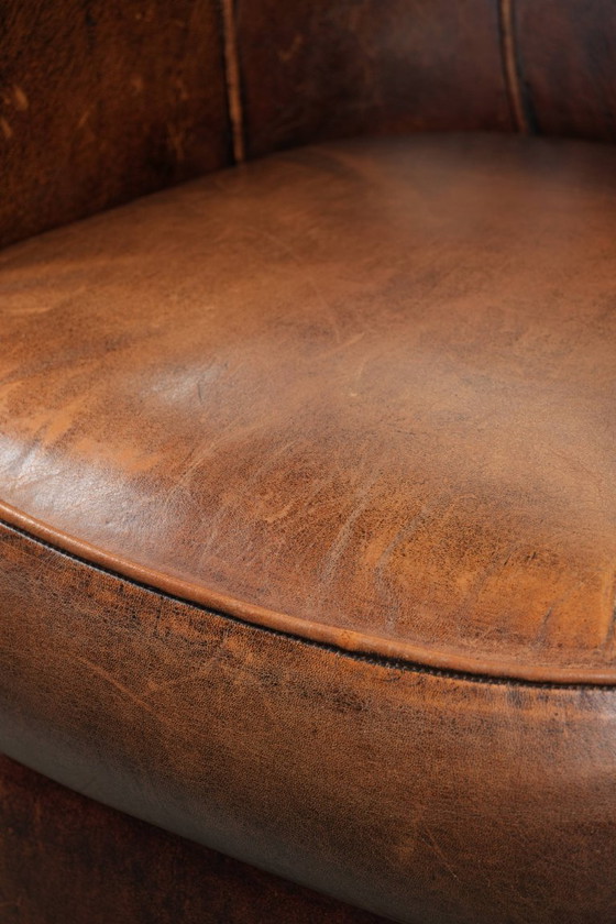 Image 1 of Karaktervolle en comfortabele clubfauteuil gemaakt van schapenleer met een vast zitkussen en uitmuntende kleuren