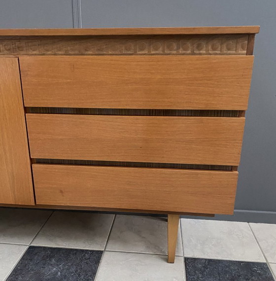 Image 1 of Dressoir uit de jaren 70 met decoratieve lijn boven de deuren.