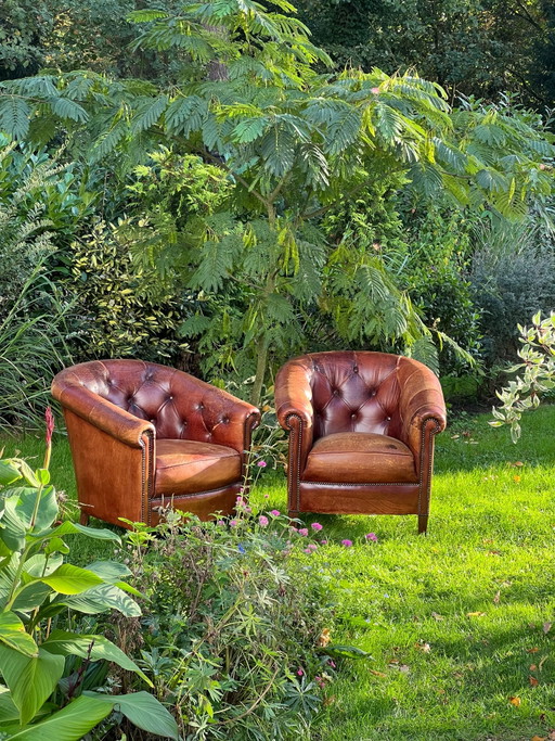 Set de 2 sillones club clásicos de cuero color coñac cálido con un aspecto inglés atemporal.