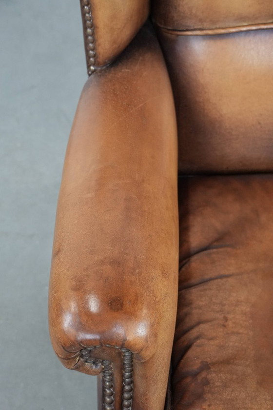 Image 1 of Sillón orejero de piel de oveja acabado con clavos decorativos