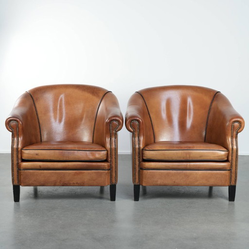 2 grands fauteuils club en peau de mouton, en bon état