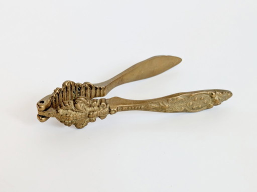 Cascanueces antiguo de latón con flor de lis, decoración floral ornamentada para cocina estilo Hollywood Regency.