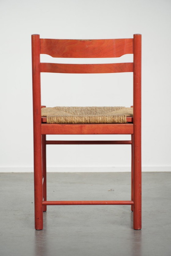 Image 1 of Schöner roter Vintage-Holzstuhl aus den 70er Jahren mit einer Sitzfläche aus geflochtenem Rohrgeflecht.