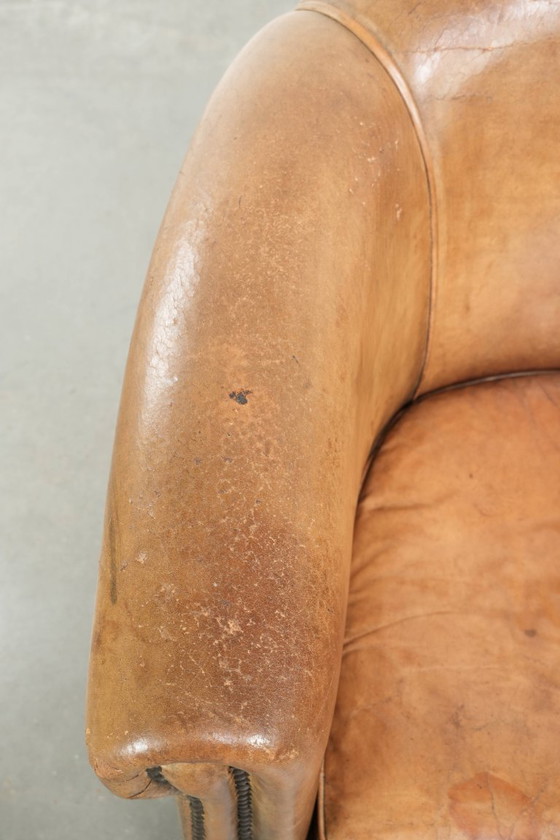 Image 1 of Vintage sheepskin club armchair with beautiful colors and finished with decorative nails.