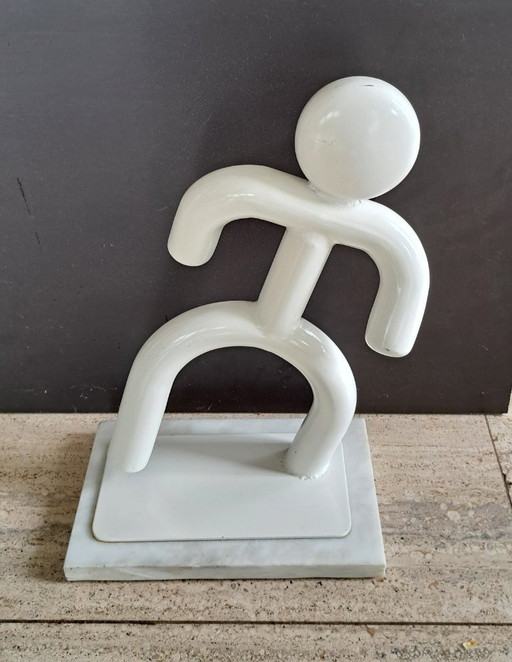 Dancing man made of metal on marble base