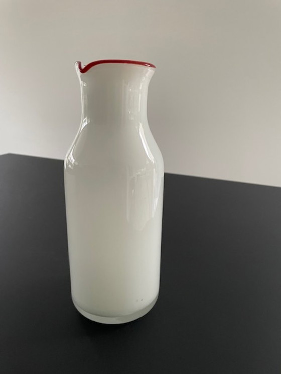 Image 1 of Caraffa dal design scandinavo in vetro bianco con bordo rosso.