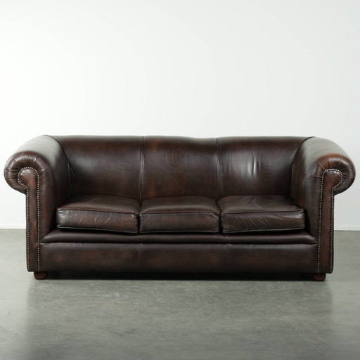 Lussuoso divano Chesterfield in morbida pelle bovina marrone, dal look inglese senza tempo.