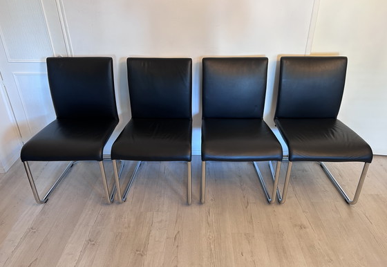 Image 1 of Ensemble de salle à manger Hülsta D2 – table à manger en verre avec 4 chaises en cuir noir à piètement luge