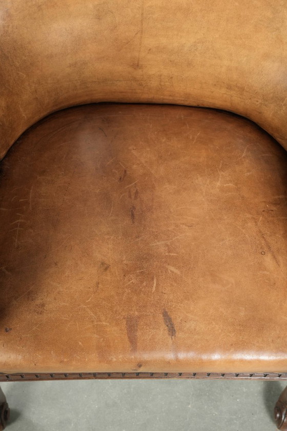 Image 1 of Antique armchair of sheepskin and wood with decorative nails and beautiful woodwork