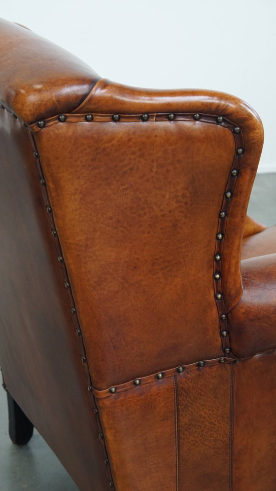 Image 1 of Comfortabele schapenleren oorfauteuil met een prachtige warme kleurstelling en een afwerking met stiksels en zwarte biezen