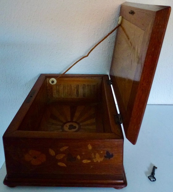 Image 1 of Una scatola di legno d'epoca con intarsi floreali