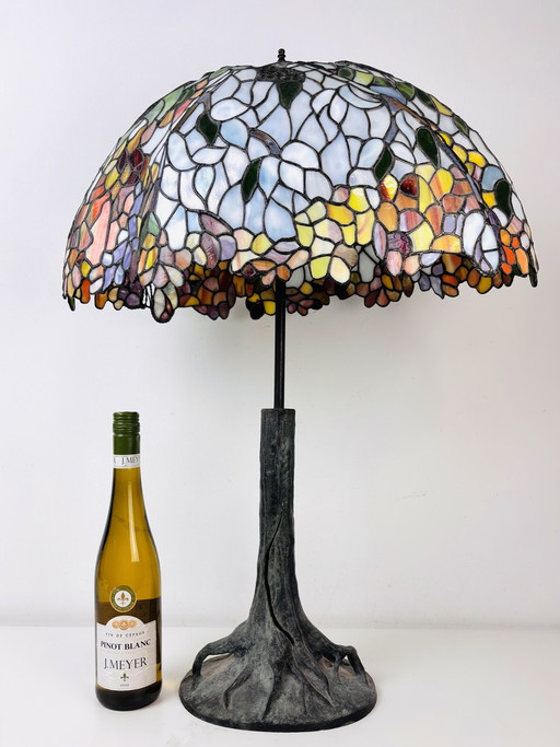 Lámpara de mesa Tiffany extragrande con base de tronco de árbol y pantalla floral.