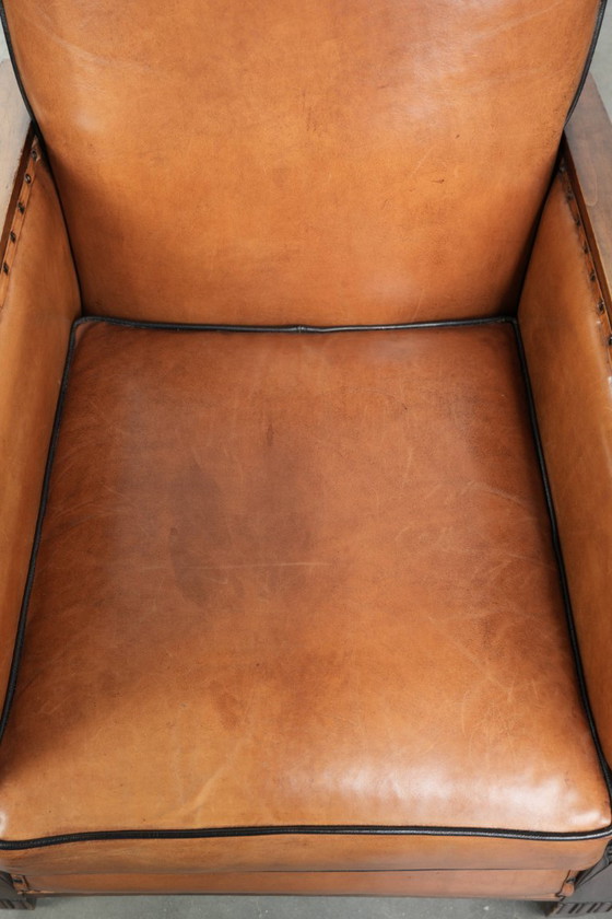 Image 1 of Schapenleren art Deco fauteuil met mooi houtsnijwerk en zwarte biezen