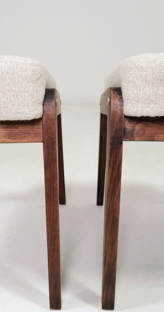 Image 1 of Par de taburetes de madera tapizados en tela beige.