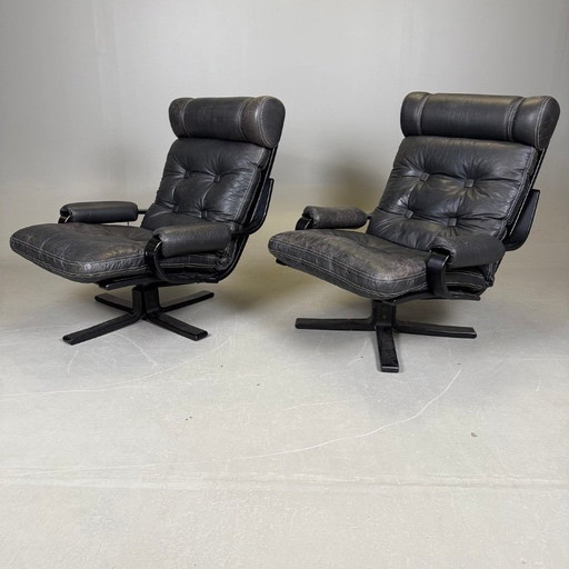 Pair of black leather, metal and wood Mid-Century Modern spinning armchairs in good condition with small signs of aging, 2 items