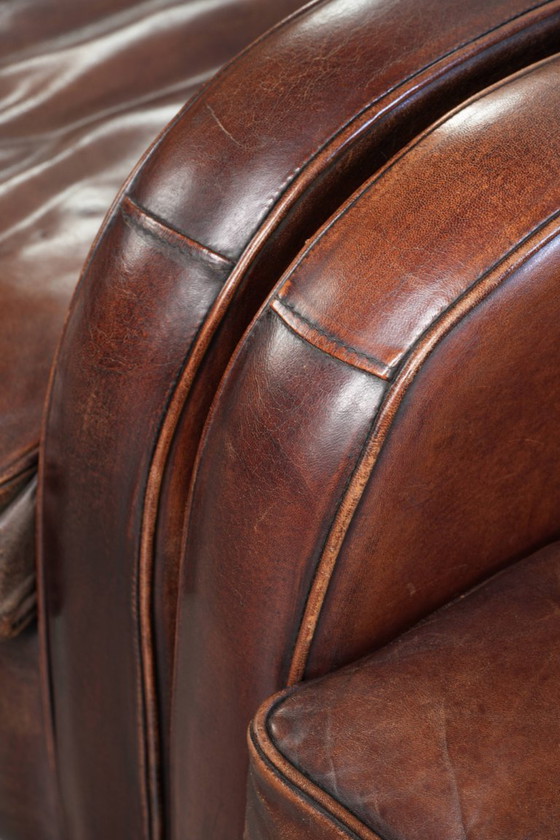 Image 1 of 2x dunkel cognacfarbene Schaffellsessel mit abgerundeten Formen und elegantem Design