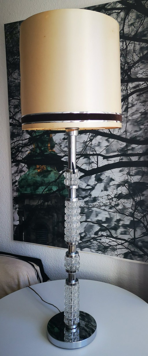 Staande lamp uit de jaren 70, de voet is gemaakt van verchroomd metaal en glas.