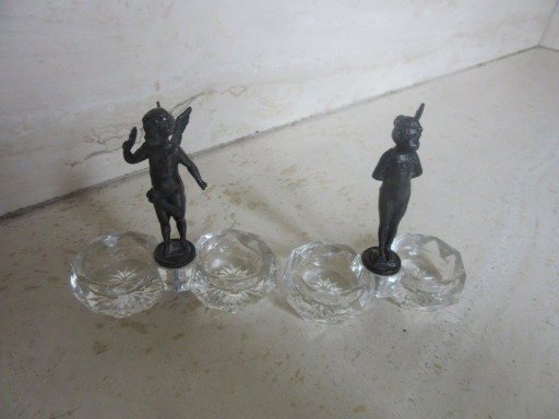 2 recipientes para salero y pimentero con forma de ángeles querubines de cristal y metal negro (a uno de ellos le falta un ala) 