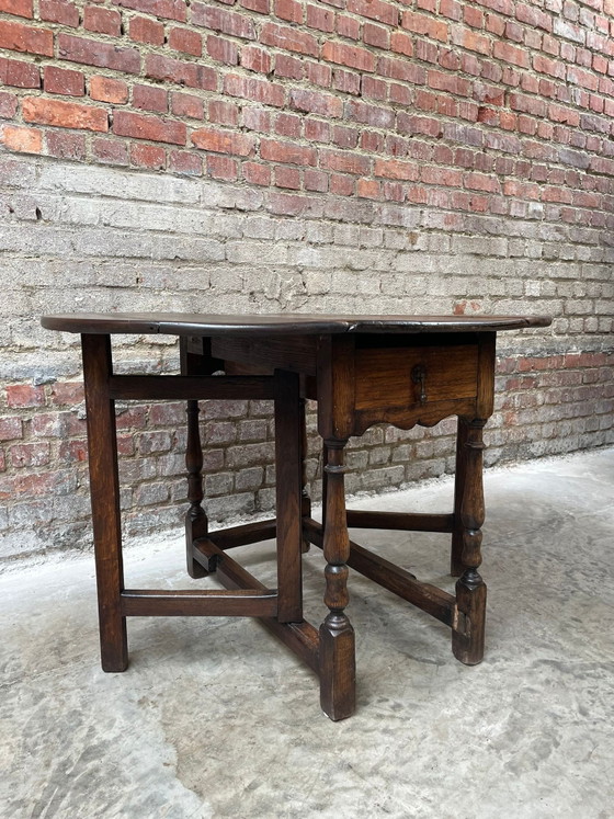 Image 1 of Tavolo antico in rovere con gambe a ribalta e cassetto