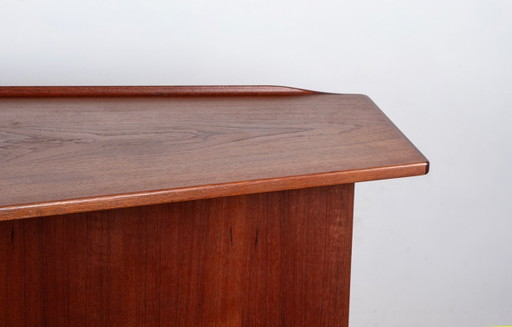 Escritorio danés en forma de "boomerang" de teca y latón, diseñado por Peter Lovig Nielsen en 1968.
