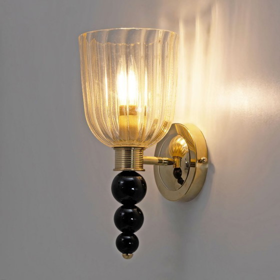 Image 1 of Een paar Italiaanse wandlampen van Murano-glas met goudstofaccenten en messing.