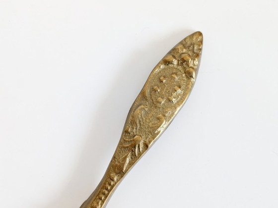 Image 1 of Vintage messing notenkraker met fleur-de-lys, sierlijke bloemenversiering voor een Hollywood Regency keuken.