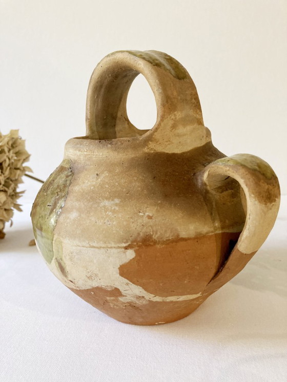 Image 1 of Klein Provençaals kannetje in de vorm van een geit, gemaakt van crèmewit en lichtgroen geglazuurd aardewerk.