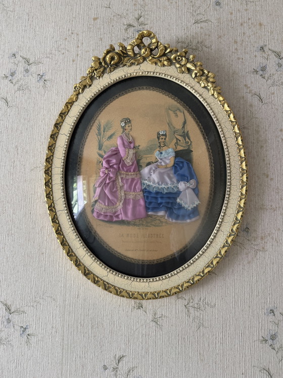 Image 1 of 
Romantic vintage oval frame featuring a delicate “La Mode Illustrée” fashion print, enhanced with hand-applied textile details.