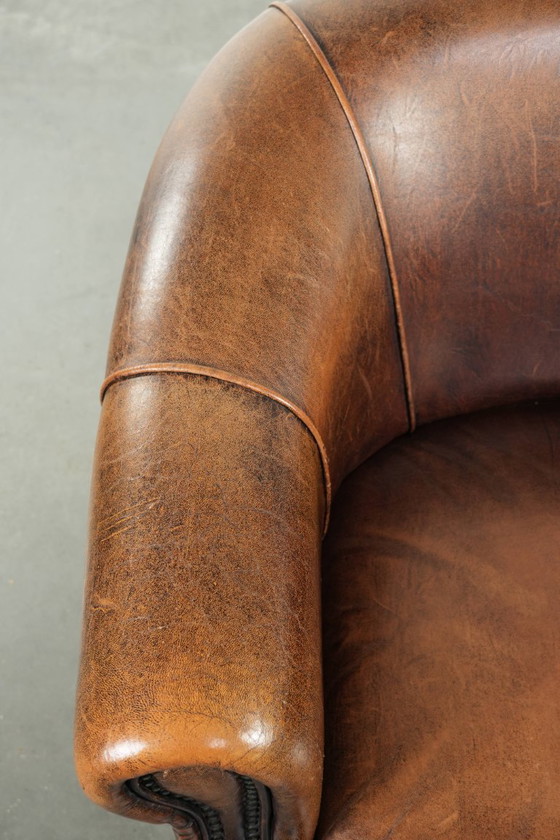 Image 1 of Karaktervolle en comfortabele clubfauteuil gemaakt van schapenleer met een vast zitkussen en uitmuntende kleuren