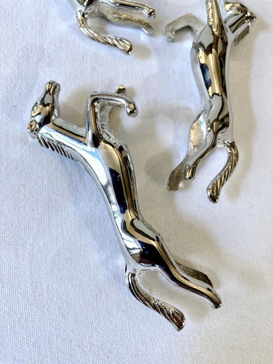 Image 1 of Cinco reposacuchillos de metal plateado con forma de caballo. Años 60.