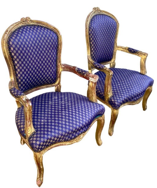 Een paar barokke fauteuils in Lodewijk XV-stijl, bekleed met blauwe satijnen stof met patronen.