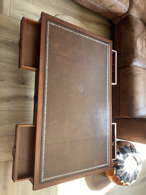 ornate English style coffee table with a brown/red leather top with 4 drawers.