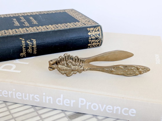Image 1 of Vintage messing notenkraker met fleur-de-lys, sierlijke bloemenversiering voor een Hollywood Regency keuken.