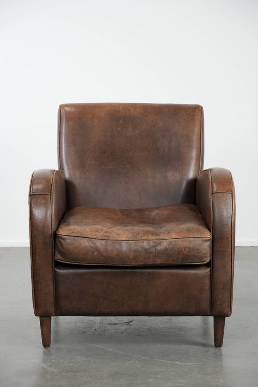 Sillón de piel de oveja con hermosas formas redondas y un diseño elegante.