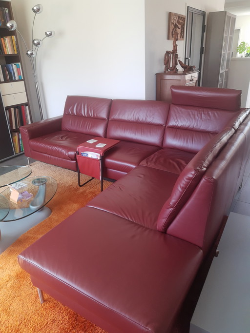 Elegante divano in pelle rosso scuro, con comandi reclinabili elettrici.