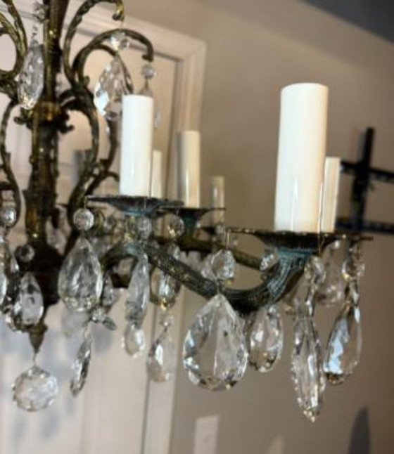 Image 1 of Lampadario antico vintage in ottone fuso decorato con 16 candele e 8 bracci in cristallo