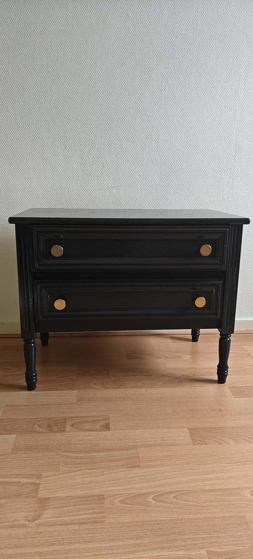 schwarze Kommoden mit goldenen Knöpfen