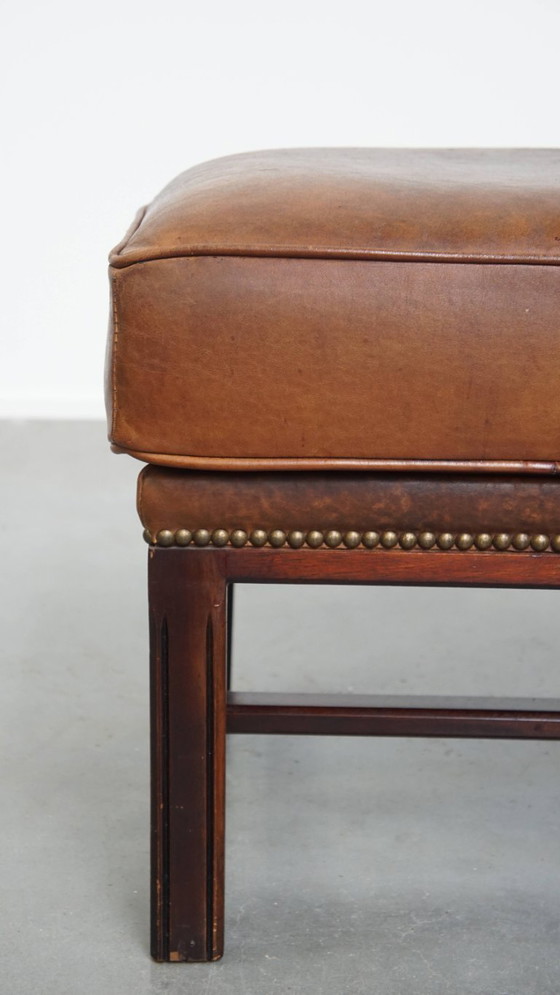 Image 1 of Hocker in pelle di pecora con struttura in legno e finitura con rivetti decorativi