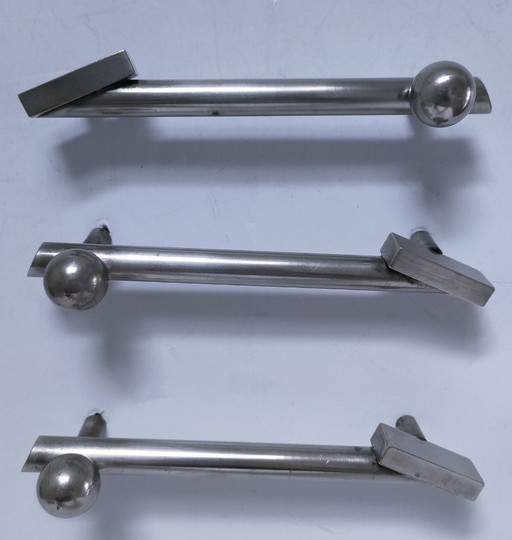 three art deco silver-tone cover handles