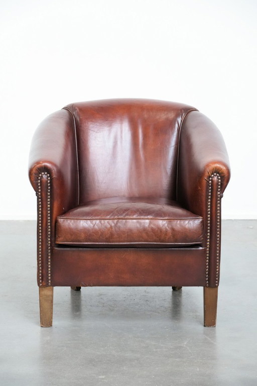 Vintage clubfauteuil gemaakt van schapenleer met siernagels