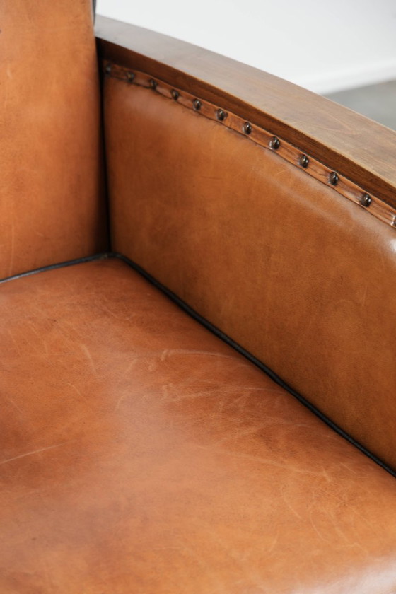 Image 1 of Schapenleren art Deco fauteuil met mooi houtsnijwerk en zwarte biezen