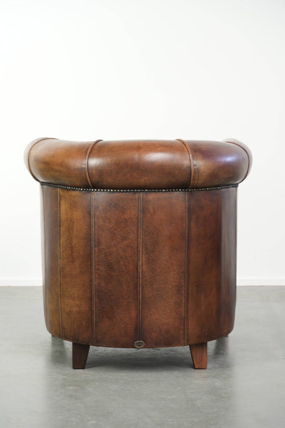 Sturdy and characterful sheepskin club armchair with a beautiful patina, finished with decorative nails. (photo 4 of 12)