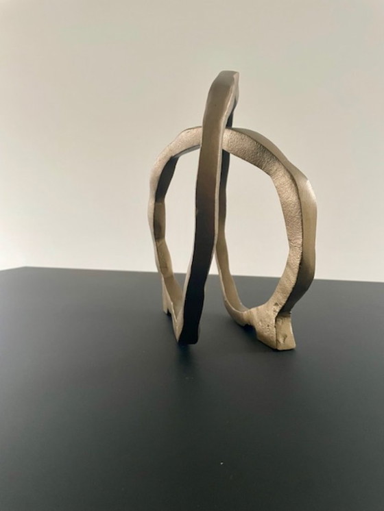 Image 1 of Escultura de diseño con forma de anillo abierto en oro mate.