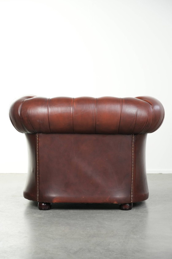 Image 1 of Beautiful red/brown cowhide Chesterfield armchair in a classic English style